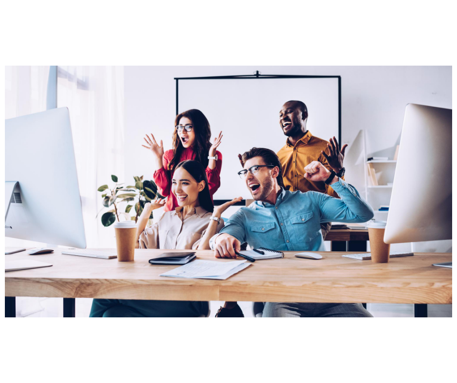 Excited office workers cheering at computer